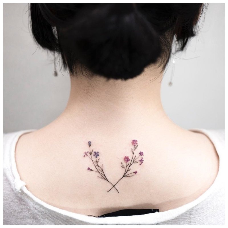Delikatne kwiaty - tatuaż na szyi dziewczyny z tyłu