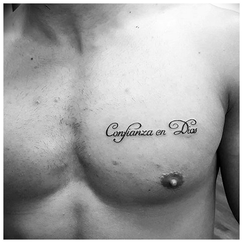 Kleine tattoo-inscriptie op de borst.