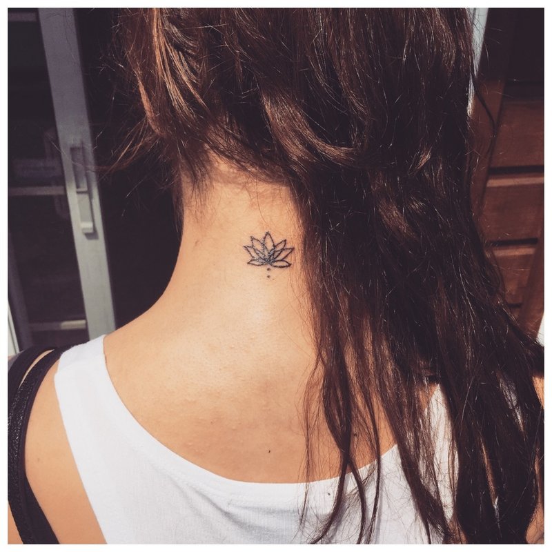 Kleine bloem - een tatoeage op de nek van een meisje