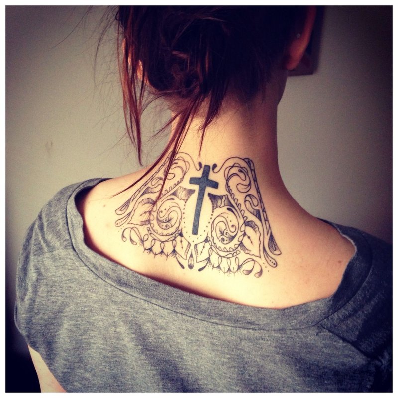 Tattoo kruis op de nek van het meisje in de rug