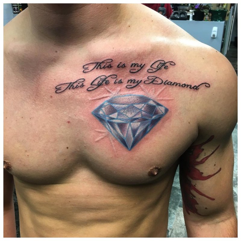 Hermoso tatuaje en forma de una inscripción en el pecho de un hombre